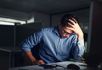 Image showing Stressed, tired business man suffering from headache, working late night in the office. Worried male entrepreneur thinking about problems and project deadline feeling burnout, distress and exhausted.