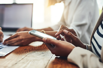 Image showing Closeup of a businesswoman hands on the phone texting colleagues, replying to messages or social media. Marketing professional female taking a break from working together with her team on a project