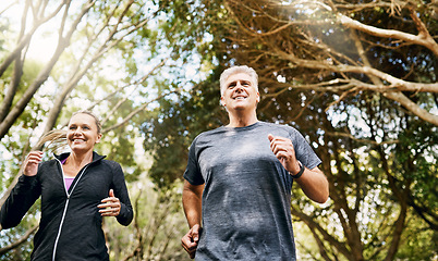 Image showing Fit, active and healthy mature couple jogging, running and enjoying their fitness lifestyle outside in nature during summer. Happy, smiling and free senior man and sporty woman exercise together