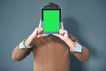 Image showing Tablet with green screen, chroma key and copy space held by man against grey background. Technology and advertising or marketing of a digital business at a workplace. Creativity online and innovation