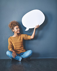 Image showing Smiling woman holding a blank white speech bubble and copyspace. Lady looking at an empty cut out to announce a sale or marketing concept. Female voice opinion on a social media chat display