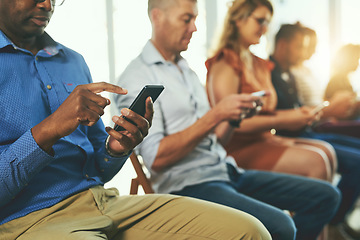 Image showing Casual modern business people texting on social media networking applications, on their digital mobile phones. Group of professionals texting on their cellphones together in a row