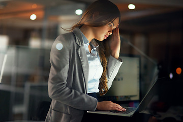 Image showing Stressed, worried and tired female entrepreneur typing on a laptop and working overtime late at night. Frustrated and overworked young businesswoman with a headache doing a project with a deadline