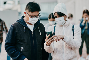 Image showing People in covid face mask and phone searching information online looking at the news on travel ban restriction on social media while stranded at the border. Modern foreign traveling people at airport