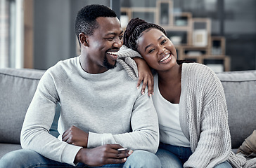 Image showing Happy, in love, and carefree couple relaxing, smiling and laughing together at home portrait while enjoying their weekend spent indoors. Young African wife and loving husband bonding on their couch