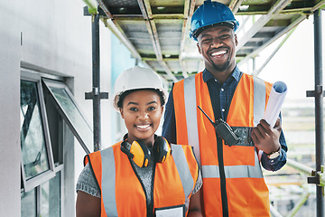 Image showing Happy and proud African American engineers at a construction site planning a building together. Portrait of young contractors standing at an apartment to be renovated for a project together