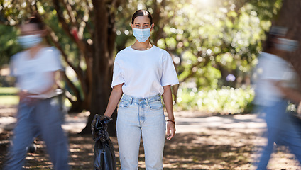 Image showing Female wearing covid mask cleaning the park for a clean, hygiene and safe green outdoor environment. Community service, volunteers or activist workers with rubbish, trash and garbage in a plastic bag