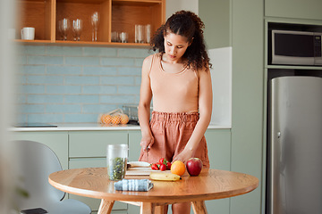 Image showing Healthy, wellness lifestyle and diet meal plan preparations or woman making breakfast fruit salad or smoothie on home kitchen table. Female preparing organic vegan food, cutting fresh ingredients.