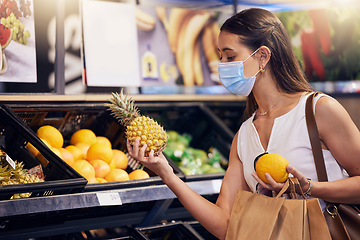 Image showing Shopping, holding and looking at fruit at shop, wearing mask for safety and protecting from covid at a grocery store. Young woman buying healthy produce, choosing items and examining at market