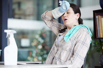 Image showing Tired, stressed and frustrated cleaning lady resting after doing chores, hygiene and housework alone indoors. Exhausted and overworked domestic housewife wiping sweat with gloves on a break at home