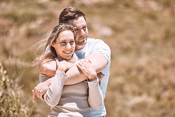 Image showing Love, romance and dating with an affectionate young couple hugging, bonding and spending time together outside. Happy, loving and smiling man and woman embracing during a date outdoors in nature