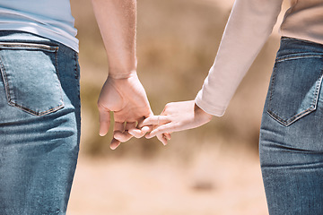 Image showing Affectionate couple holding hands showing love, caring and bonding outside together in nature. Loving boyfriend and girlfriend expressing unity, understanding and trust in their relationship