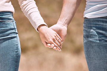 Image showing Couple holding hands, love and care showing affection, friendship and romance while on a walk together in nature. Closeup of boyfriend and girlfriend expressing loving, caring and comforting emotion