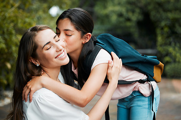 Image showing Daughter, hugging and giving a kiss to her mom before going into school. Happy parent has strong relationship and cute bond with her child. Young girl shows love, affection and care for her mother.