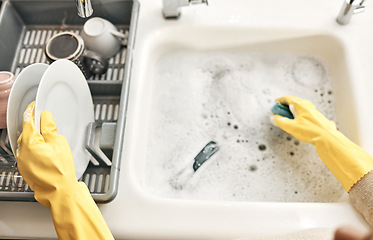 Image showing Housewife, maid or cleaner hands washing dishes in the kitchen sink for home hygiene, wearing rubber gloves. Contact us for cleaning solutions or professional domestic household chores service.