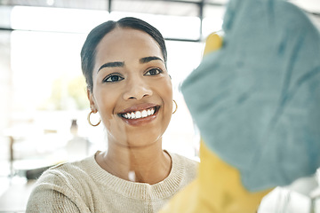 Image showing Cleaning, chores and cleaner wiping windows with a soft cloth while wearing gloves in office. Smiling, young and female maid doing hygiene housekeeping. Beautiful lady keeping her home clean.