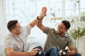 Image showing Men high five, celebrate and enjoy playing video games in the sofa at home. Happy, cheerful and best friends having fun and winning while holding wireless controllers with live online game