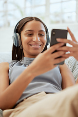 Image showing Happy, smiling woman listening and browsing music on her phone during a break at work. Business woman enjoying some free alone time at the office texting and catching up on her social media.