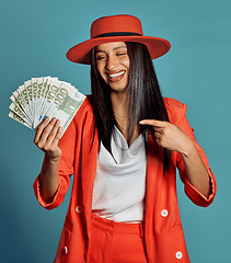 Image showing Rich young woman holding cash, competition or lottery winnings pointing looking stylish, elegant and trendy. Happy, excited and celebrating female cheering with income, savings or investment returns