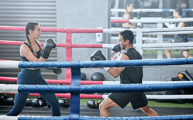 Image showing Boxing, training and exercising with a healthy, fit and active female boxer and her male coach or personal trainer in the gym. Workout, fitness and exercise with an athlete and her sports instructor