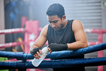 Image showing Sad, lose and defeated athlete looking tired after workout, unhappy and drinking water after boxing for fitness. Young, sporty and Asian man breathing heavily, resting and taking break from exercise