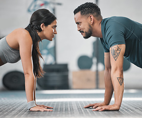 Image showing Fitness, gym and training couple doing an exercise workout and living an active, healthy and sporty lifestyle together. Serious, toned and athletic young friends using teamwork to get a stronger body