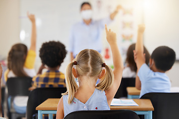 Image showing School students raising hands to volunteer, participate and answer during lesson while learning in a classroom. Teacher asking questions to eager, smart and clever young kids questions for education