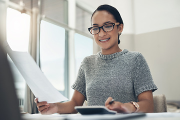 Image showing Home budget, finances and bills being calculated by a young woman sitting at home. Young female calculating her expenses, debt and spendings while doing monthly tax returns or planning in the lounge