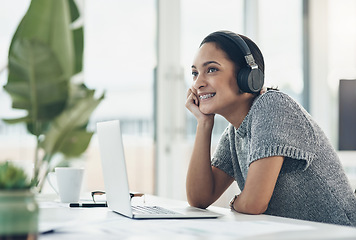 Image showing Happy, smiling business woman day dreaming of success at her office desk in a modern office. Female office worker enjoying a podcast or songs during a break in a corporate company over copy space.