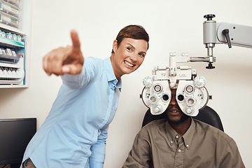 Image showing Happy optometrist doing eye test on a patient, examining vision and doing optical exercise at an optometry checkup. Young black man consulting with an opthalmologist, measuring and checking eyesight