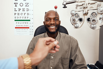 Image showing Black man having his eyes tested at an optometrist. Smiling African American male consulting with an opthamologist, having a vision and eye care checkup. Guy testing for glaucoma or myopia