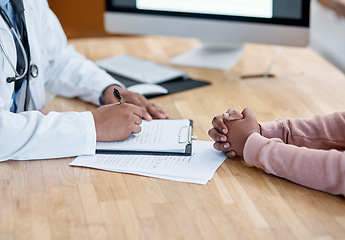 Image showing Doctor writing a prescription on paper for a patient at the hospital. Closeup of the hands of a healthcare professional drafting a medical letter or form. A GP filing a document in an office