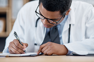 Image showing Doctor writing a prescription, survey or medical care paperwork for a patient at the hospital. A healthcare professional writing a patient information chart. A GP filing a document in an office
