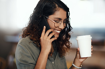 Image showing Young woman talking on her phone, drinking coffee, and smiling in cafe shop. Lady wearing glasses, using technology to network and connect while enjoying a break from work.