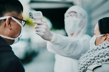 Image showing Healthcare worker testing covid temperature for protocol, compliance or countries restrictions at an airport or border. Foreign traveling people with face mask in quarantine or corona virus screening