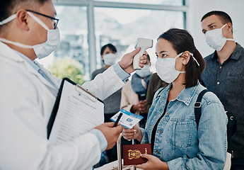 Image showing Travel restriction, covid pandemic and temperature check at airport. Asian female wearing mask for corona virus prevention waiting in departure inspection line, doctor pointing digital thermometer.