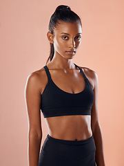 Image showing Fit, slim and serious woman feeling confident about her body and health while standing against a pink studio background. Portrait of a sporty and determined woman ready to exercise to stay in shape