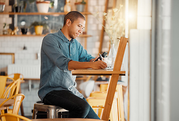 Image showing Business owner, cafe manager or entrepreneur writing notes, busy on phone and working on laptop in his startup. Young male looking looking satisfied or pleased while managing finance and capital.