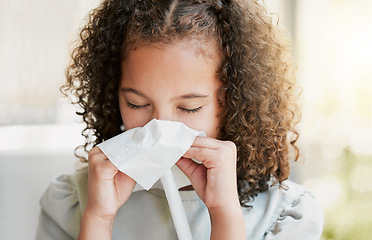 Image showing Sick, cleaning nose with tissue and tired girl kid suffering from flu virus, cold or covid at home. Closeup of a young child with a bad allergy or coronavirus sneezing with a sinus headache