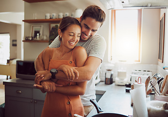 Image showing Love, romance and fun couple hugging, cooking in a kitchen and sharing an intimate moment. Romantic boyfriend and girlfriend embracing, enjoying their relationship and being carefree together