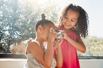 Image showing Cute sisters bonding, taking photos on camera at home, smiling while being playful and curious. Little girls playing, having fun together, enjoying their bond and sharing precious childhood moments