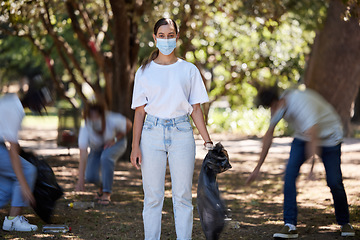 Image showing Volunteer help of covid cleaning community group working together outdoors. Portrait of a young female worker doing nature and forest clean up of plastic garbage outside to be green for the future