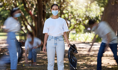 Image showing Volunteers, hygiene and environmental team cleaning a park in covid masks together. Development, energy and recycling activists working in collaboration to put messy dirt in plastic bags and trash