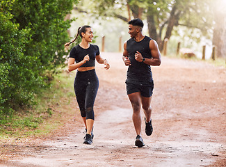 Image showing Fitness, exercise and happy couple out running or jogging on a forest trail or park outdoors. Sporty and smiling man and woman staying active and fit while exercising and bonding during a workout