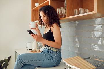 Image showing Woman texting, chatting on the phone while relaxed, carefree and sitting on kitchen counter. Young, relaxing and casual female student at home looking at social media, pictures or videos