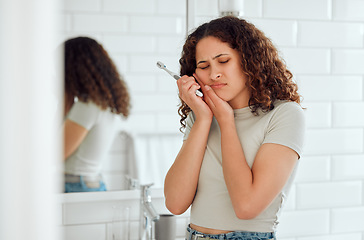 Image showing Toothache, pain and sensitive teeth with a woman brushing her teeth in a bathroom at home. Young female with a cavity suffering from discomfort during dental hygiene routine. Lady with a sore mouth