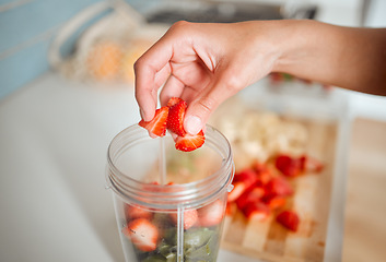 Image showing Healthy, diet and fruits while preparing a smoothie or shake in a blender at home. Making a fresh homemade organic drink with strawberries to cleanse and provide energy for vitality and health