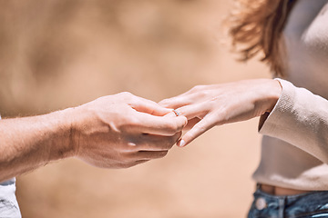 Image showing Engagement, proposal and romance while putting a ring on the finger of a woman saying yes to marriage outside. Closeup hands of a young couple telling you to save the date for their wedding day