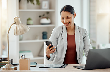 Image showing Freelance and remote working business woman checking her phone, reading a message or sending a text in her home office. Motivated, happy and positive female professional sitting at her desk at work