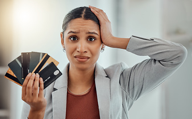 Image showing Stressed, worried businesswoman in debt from shopping at work. Female in corporate finance, money issues headache, holds credit and debit cards. Frustration, economic inflation and expenses.